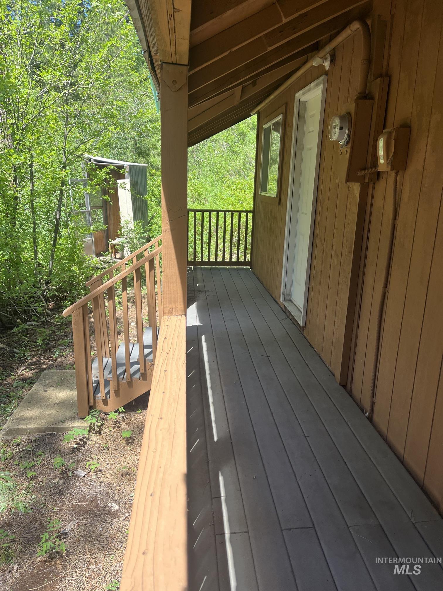 39 Mayflower Mine Road Placerville, ID 83666 - Photo 7 of 36 Wood-paneled exterior featuring a covered porch, wood-finish decking, and a perimeter railing