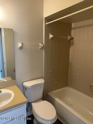 a white toilet and tub sitting next to a bathroom sink