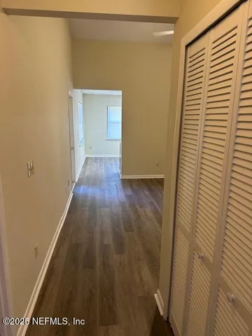 a view of a hallway with wooden floor