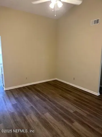 an empty room with wooden floor and chandelier fan