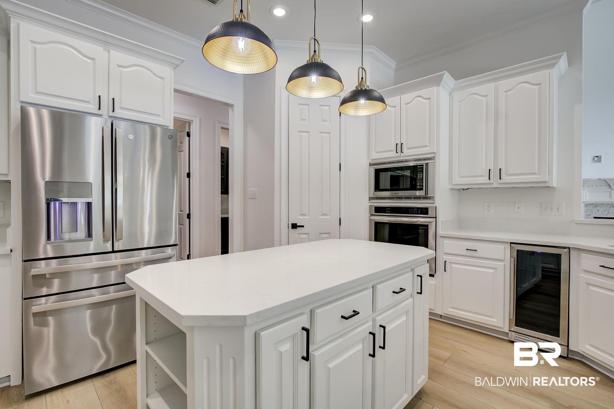 105 High Pines Ridge Fairhope, AL 36532 - Photo 34 of 97 Kitchen featuring appliances with stainless steel finishes, wine cooler, a center island, light countertops, and white cabinetry
