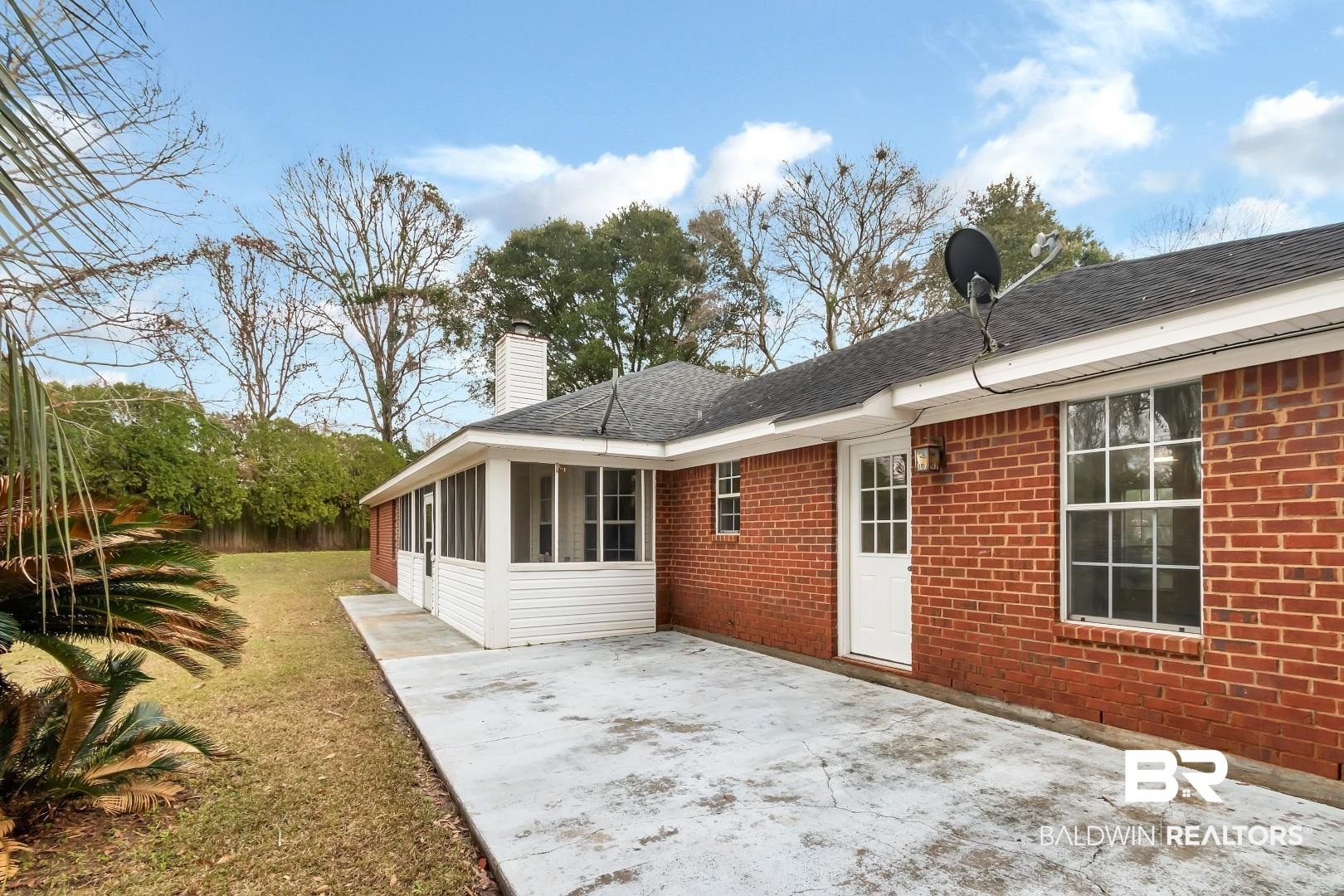 10006 Wedgefield Court Mobile, AL 36608 - Photo 2 of 34 Rear view of property with a patio, a sunroom, a chimney, a yard, and brick siding