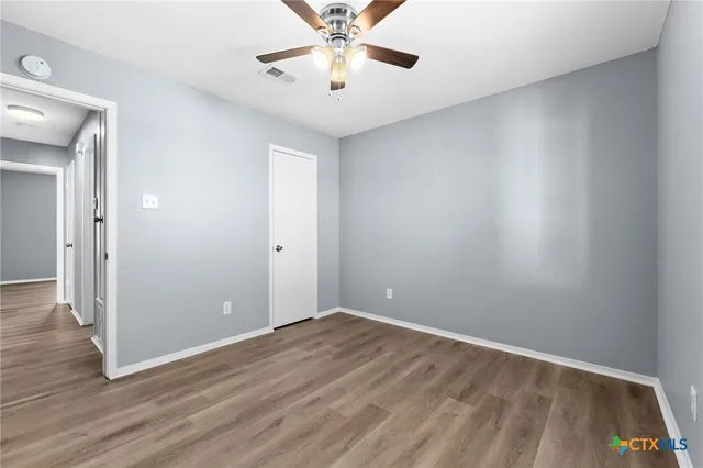 an empty room with wooden floor and door