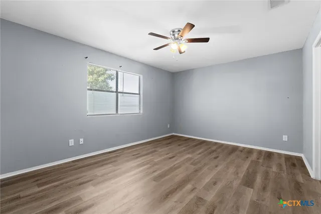 wooden floor in an empty room with a window
