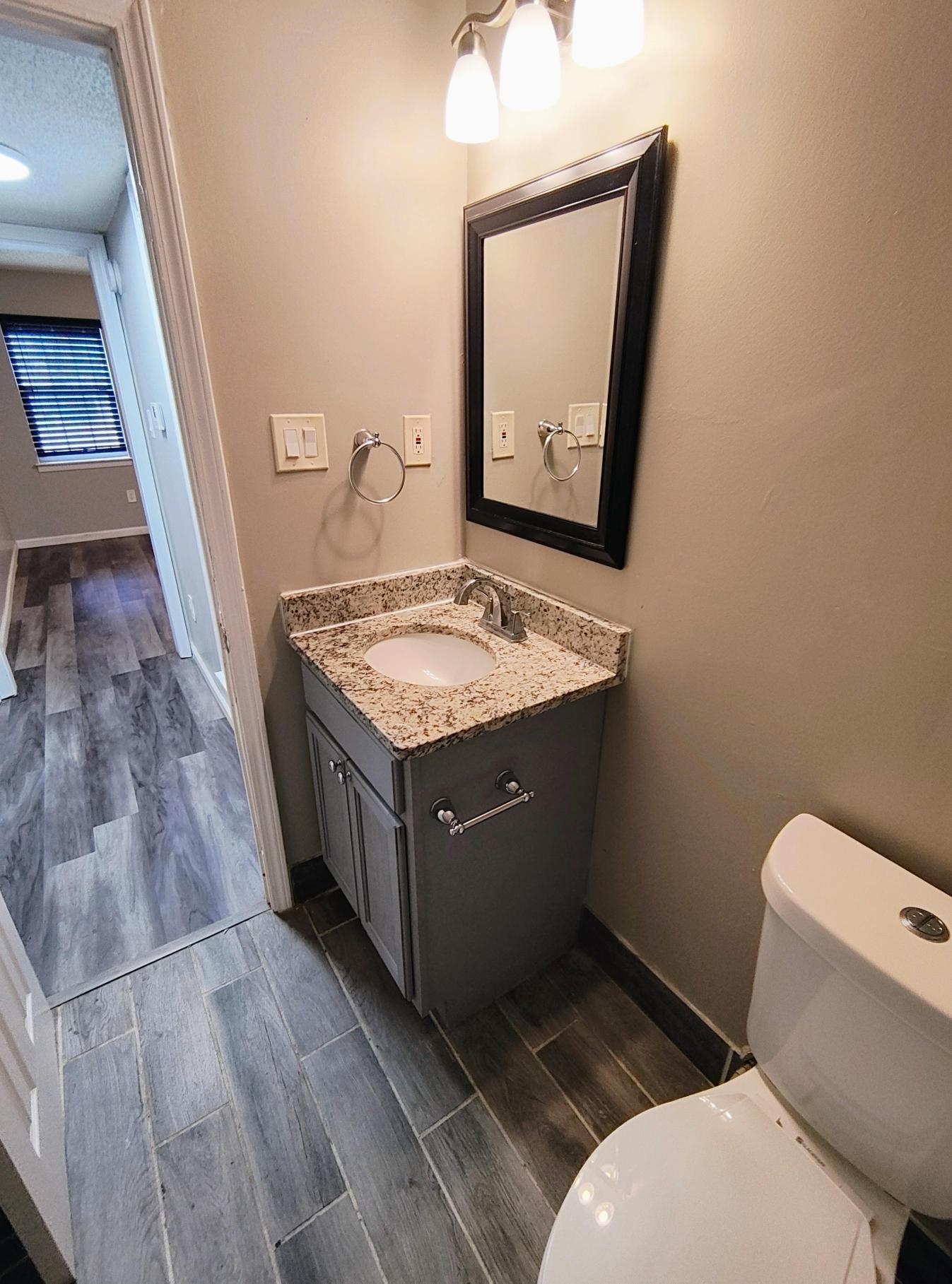 858 Pendleton Street Memphis, TN 38114 - Photo 9 of 10 a bathroom with a granite countertop toilet sink and mirror