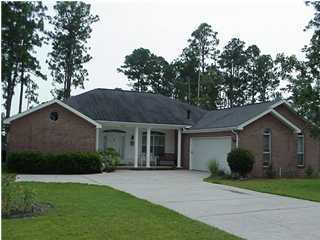 4462 Kingslynn Road Niceville, FL 32578 - Photo 1 of 15 a front view of a house with a garden and trees