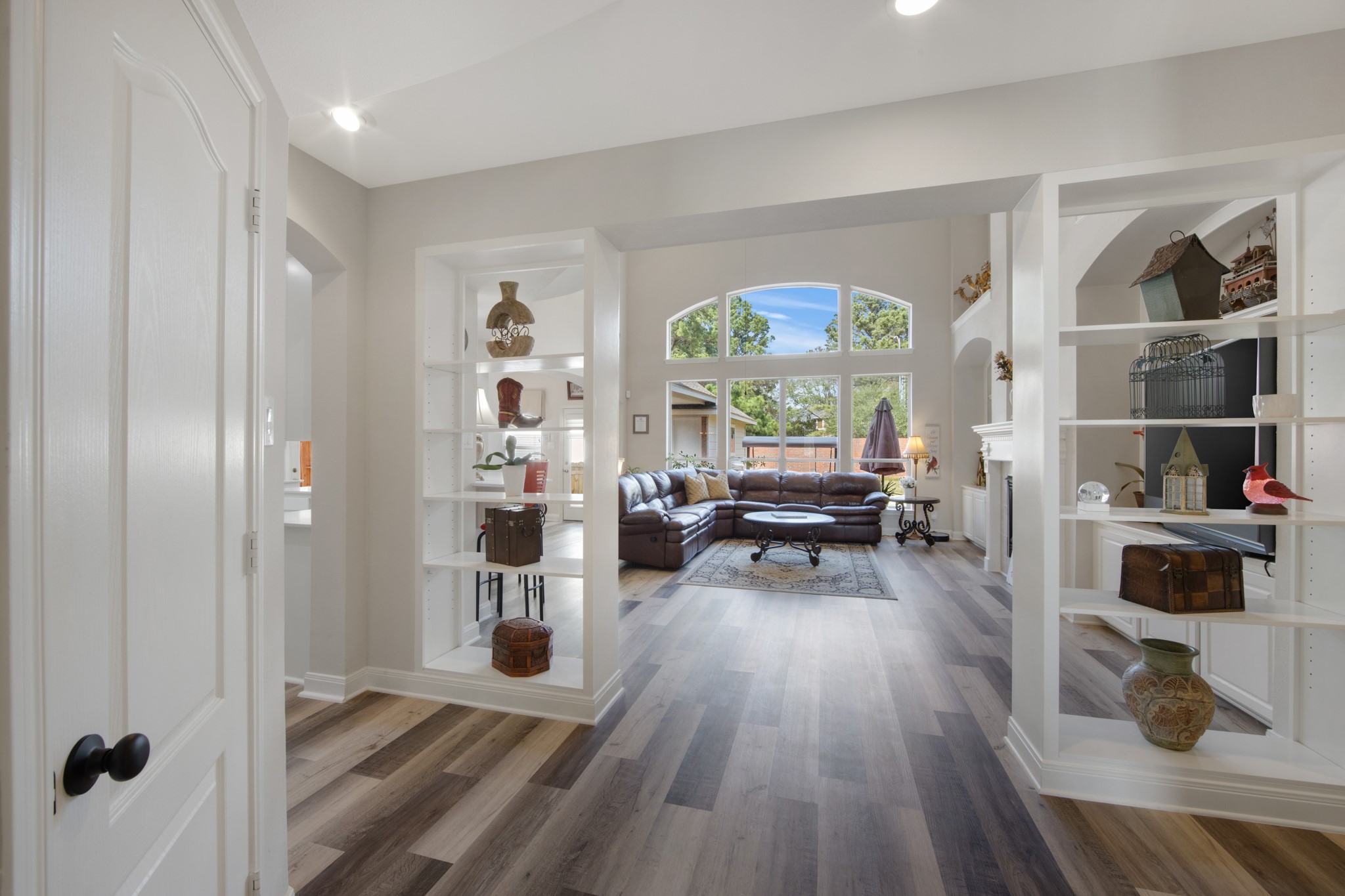 9510 Ashdown Forest Drive Spring, TX 77379 - Photo 17 of 50 LIVING ROOM – view from the entry showcasing the open concept layout and built-in shelving. The living area flows effortlessly from the foyer into the heart of the home.