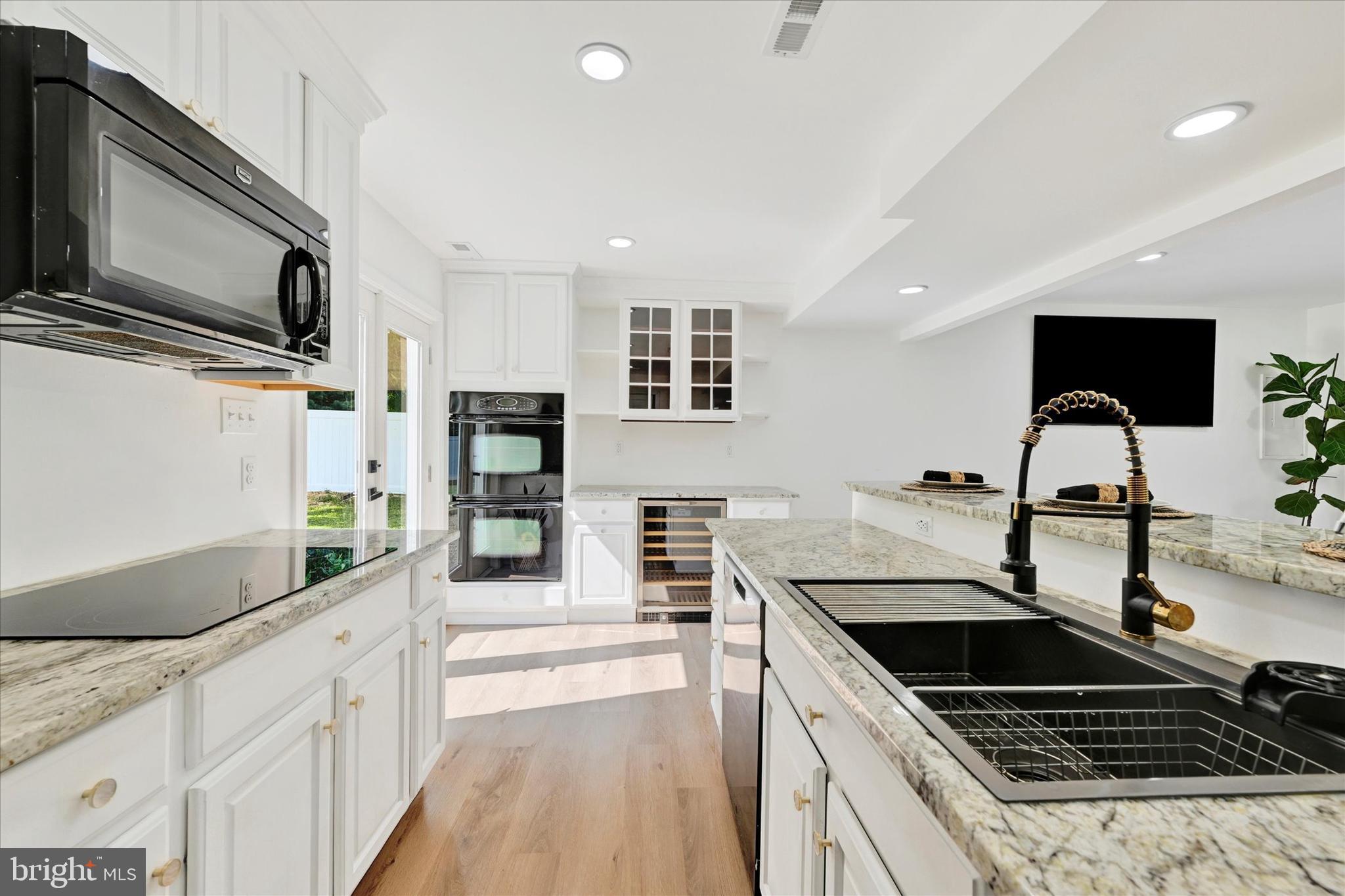 102 Maple Road Stevensville, MD 21666 - Photo 13 of 43 a kitchen with stainless steel appliances kitchen island granite countertop a sink and cabinets