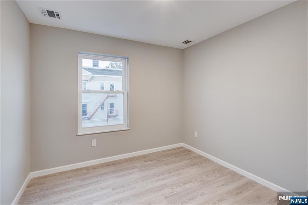 581 Bergen Street Newark, NJ 07108 - Photo 12 of 21 a view of an empty room with wooden floor and a window