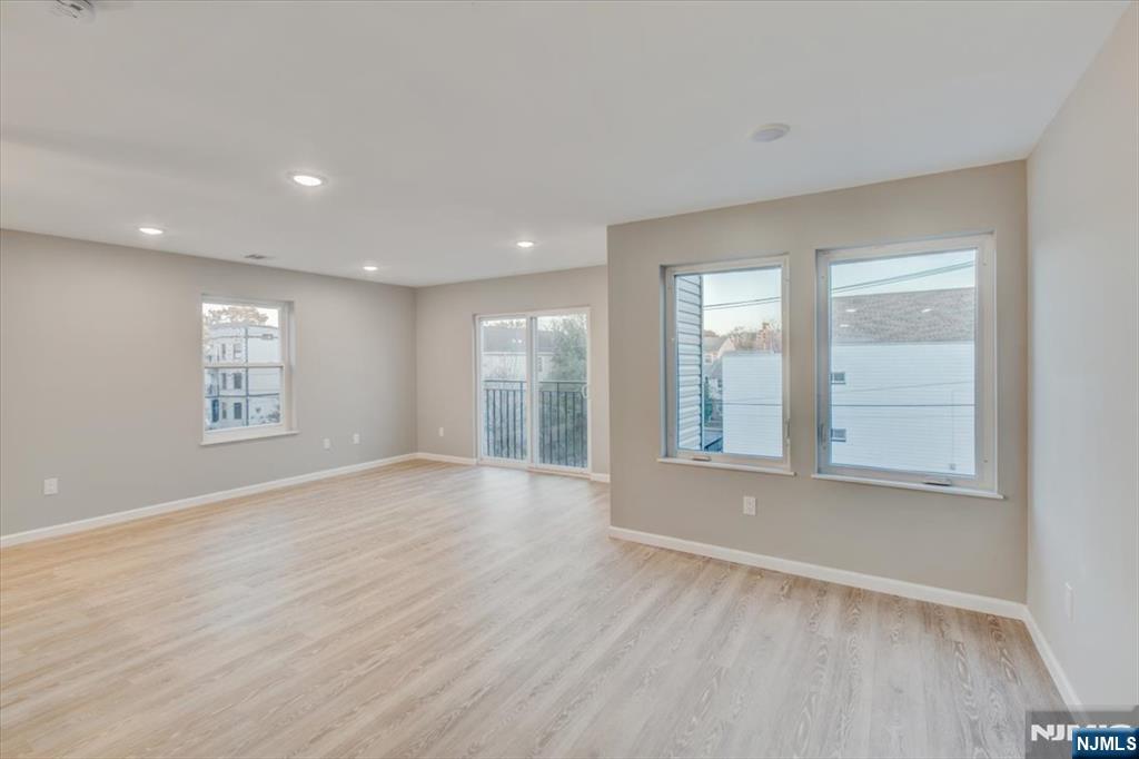 581 Bergen Street Newark, NJ 07108 - Photo 6 of 21 an empty room with wooden floor and windows