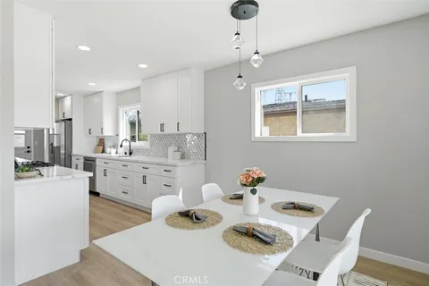 a kitchen with stainless steel appliances granite countertop a sink stove refrigerator and cabinets