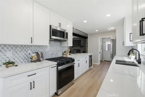 a kitchen with sink a stove and cabinets