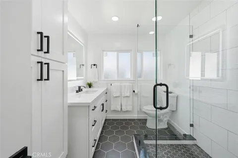 a bathroom with a sink a toilet and shower