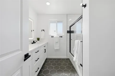 a bathroom with double vanity sink and a mirror