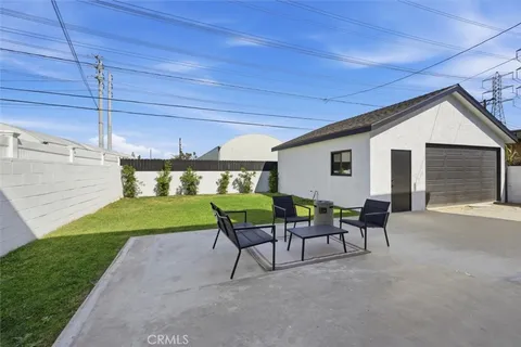 a view of a house with backyard and sitting area