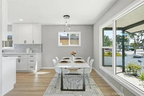 a kitchen with stainless steel appliances kitchen island granite countertop a table chairs and a stove