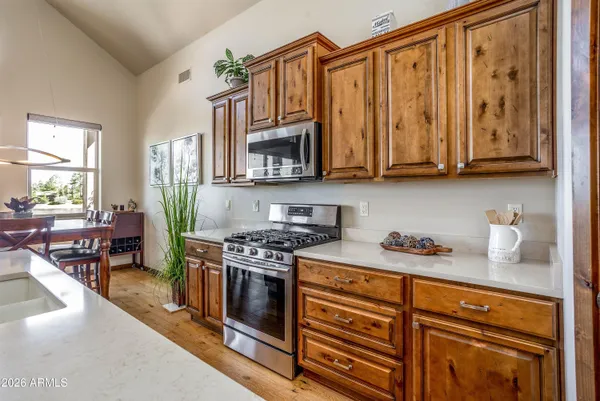 a kitchen with stainless steel appliances granite countertop a stove a sink and a microwave