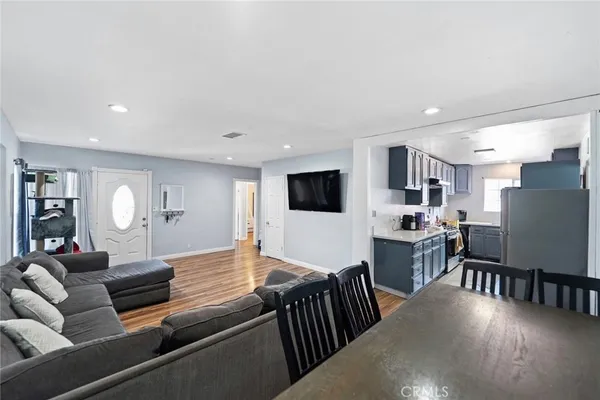 a living room with furniture kitchen view and a flat screen tv