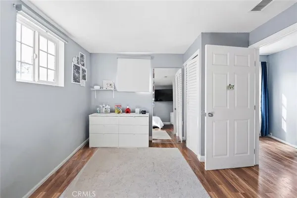 a view of hallway with window and wooden floor