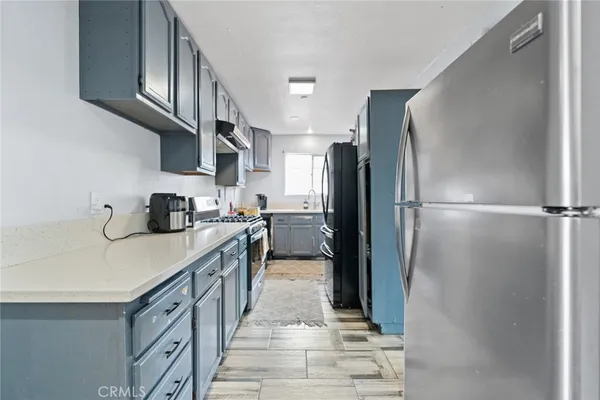 a kitchen with stainless steel appliances granite countertop a refrigerator a stove and a sink