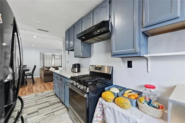 a kitchen with stainless steel appliances granite countertop a stove a sink dishwasher and cabinets with wooden floor