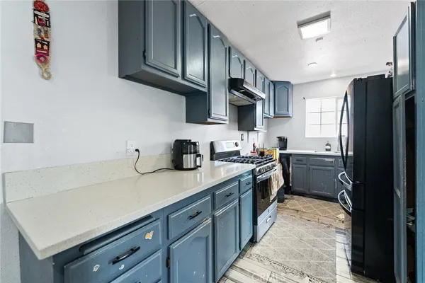a kitchen with a sink dishwasher a refrigerator and wooden cabinets