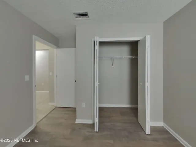 a view of an empty room with closet area