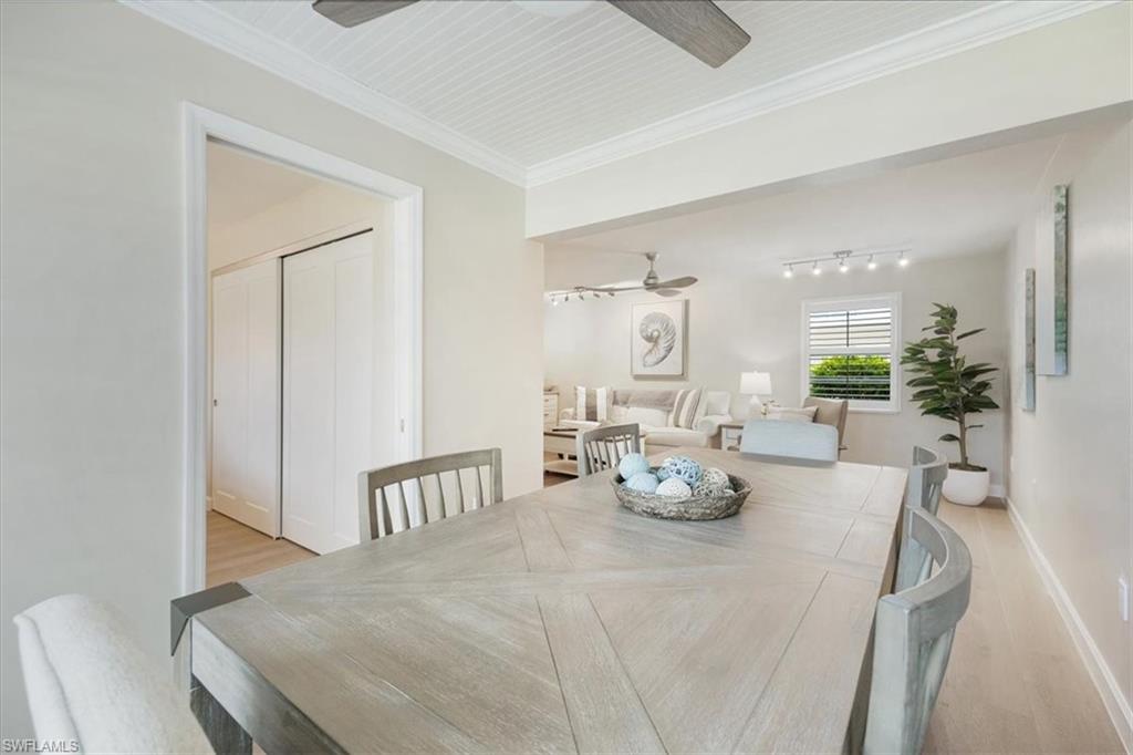 626 12th Avenue South, Unit 626 Naples, FL 34102 - Photo 17 of 50 a view of a dining room with furniture a chandelier and wooden floor