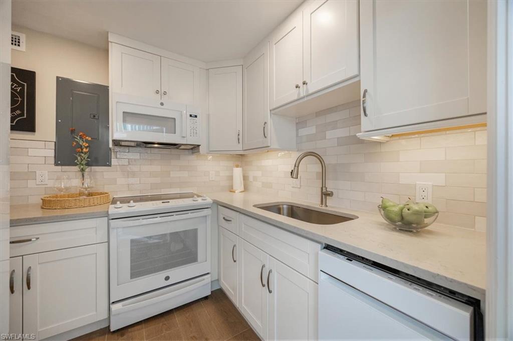 626 12th Avenue South, Unit 626 Naples, FL 34102 - Photo 23 of 50 a kitchen with sink a microwave and cabinets