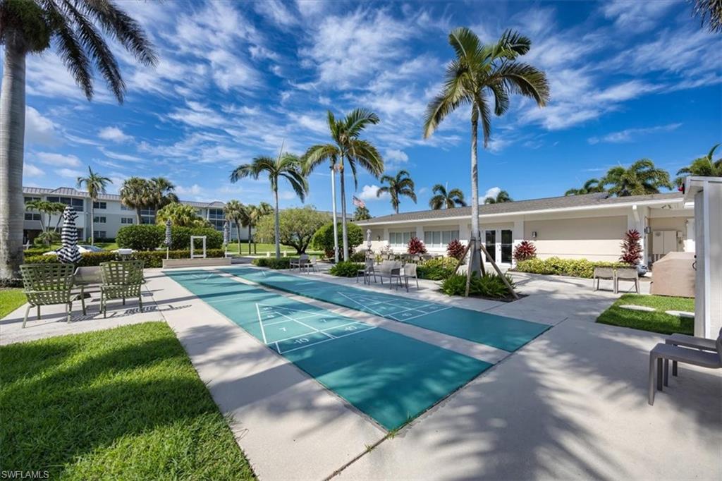 626 12th Avenue South, Unit 626 Naples, FL 34102 - Photo 49 of 50 a view of a patio with a table and chairs under an umbrella