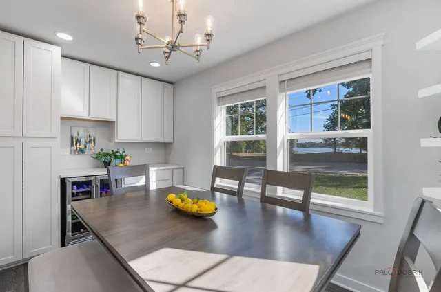 a kitchen with a dining table chairs and chandelier