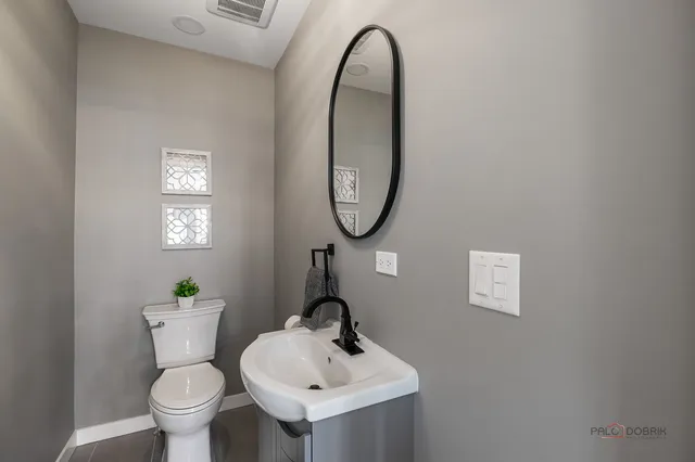 a bathroom with a toilet a sink and a mirror
