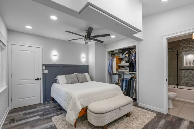 a bedroom with a large bed and a chandelier