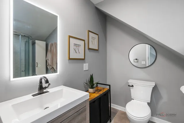 a bathroom with a toilet a sink and mirror