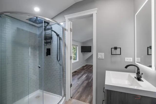 a bathroom with a shower sink and mirror
