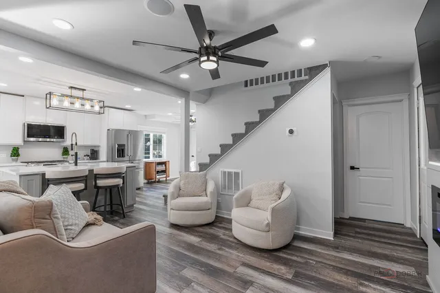 a living room with furniture and a view of kitchen