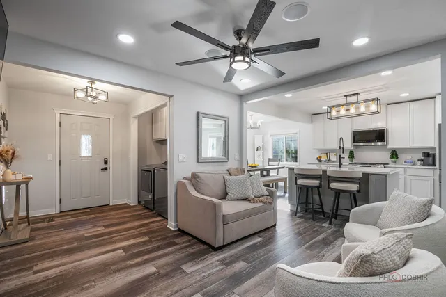 a living room with furniture kitchen and a chandelier