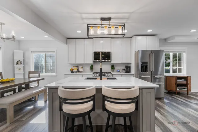 a kitchen with sink a stove and chairs
