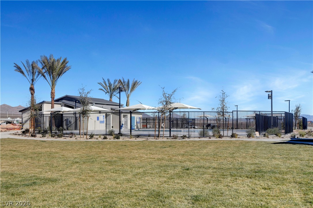 6924 Spicy Merlot Street North Las Vegas, NV 89086 - Photo 50 of 83 An inviting community pool awaits, nestled within verdant grounds and accented by mature palm trees.