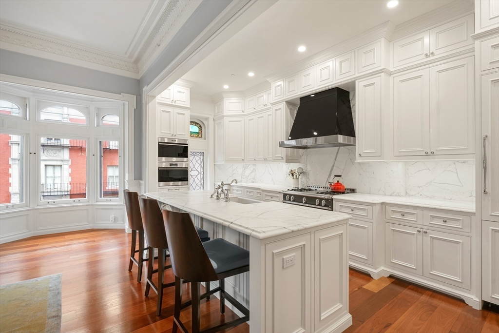 314 Commonwealth Avenue, Unit 2 Boston, MA 02115 - Photo 10 of 31 a kitchen with a dining table chairs and white appliances