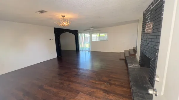 a hall with a window and wooden floor
