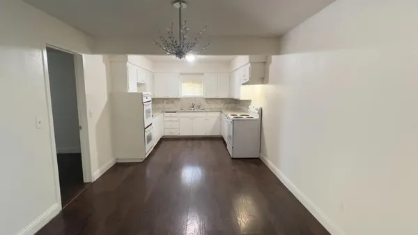 a view of a kitchen with a sink and wooden floor