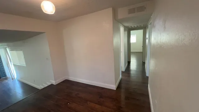 a view of a hallway with wooden floor