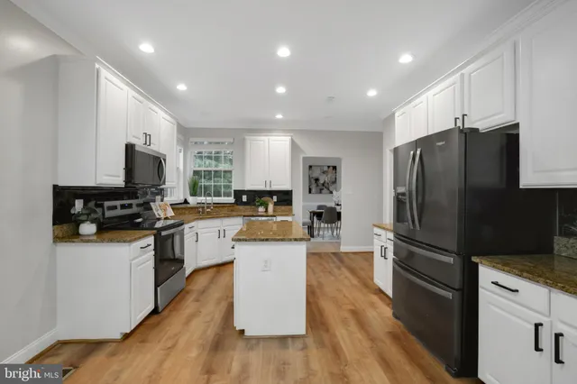 a kitchen that has a lot of cabinets a sink and appliances in it