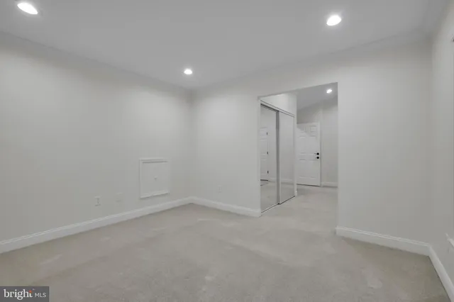 an empty room with ceiling fan and window