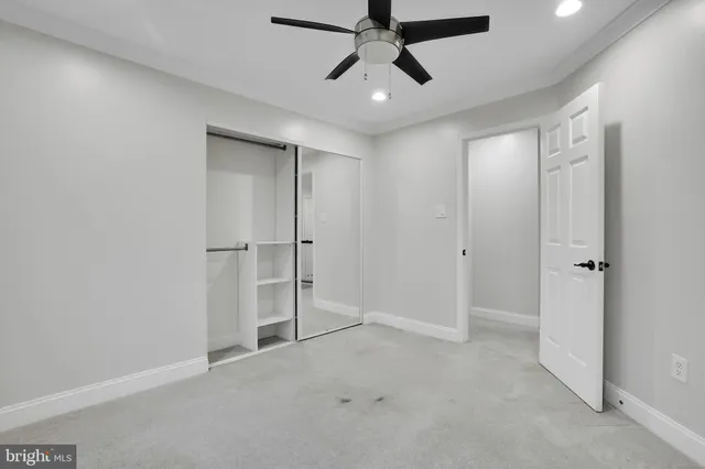 an empty room with ceiling fan and window