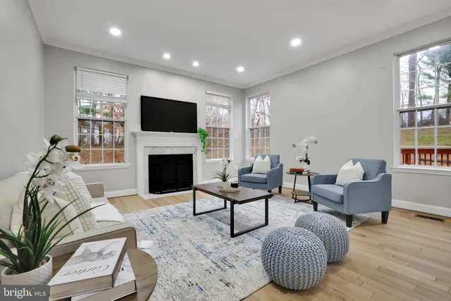a living room with furniture a flat screen tv and a fireplace