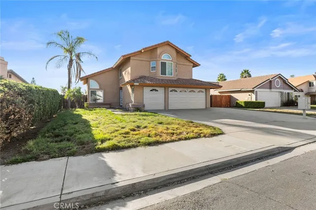 a front view of a house with a garden and yard