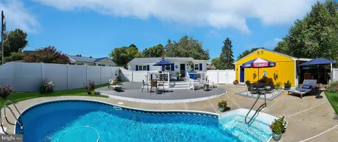 a swimming pool with outdoor seating and yard