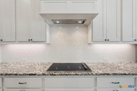 a kitchen with granite countertop a sink a counter top space appliances and cabinets